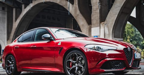 Red Alfa Romeo Giulia Quadrifoglio parked under bridge