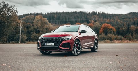 Red RSQ8 parked in front of forest trees